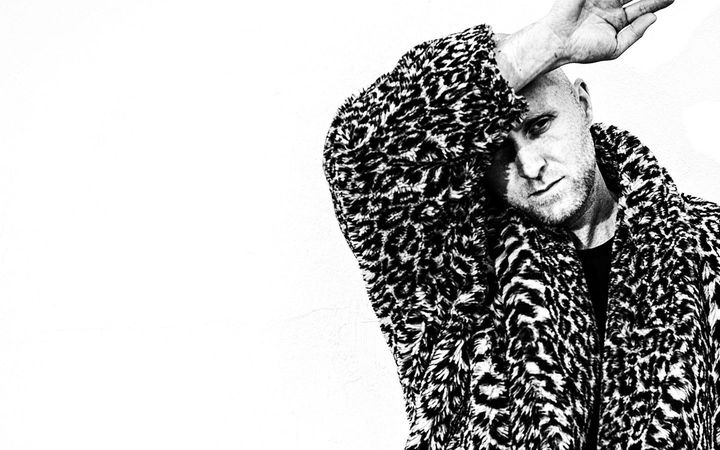 Black-and-white portrait of Ísak Morris in a leopard-print coat